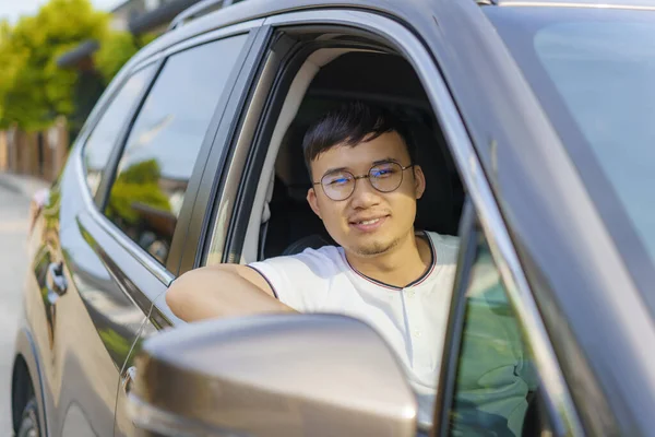 亚洲快乐的年轻英俊男子笑着坐在前排的汽车上 准备开车上路 — 图库照片