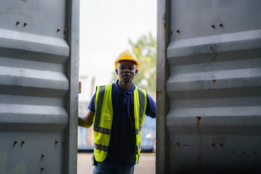 Afro-Amerikalı siyahi işçiler kontrol için konteynırları açıyorlar ve depo terminalinde tamiratın tamamlanıp tamamlanmadığını kontrol ediyorlar.