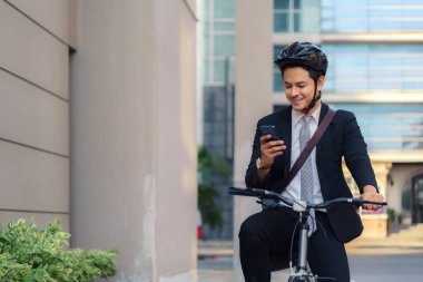 Asyalı işadamı cep telefonlarını uygulamaları, haritaları ve sabah işe gidiş yönlerini görmek için kullanıyor.