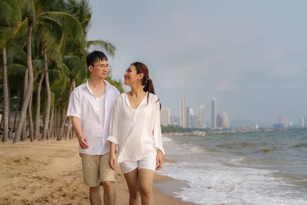 アジアのカップルは タイの夏の休暇中にヤシの木とビーチビーチの海を歩き 抱き合っています — ストック写真