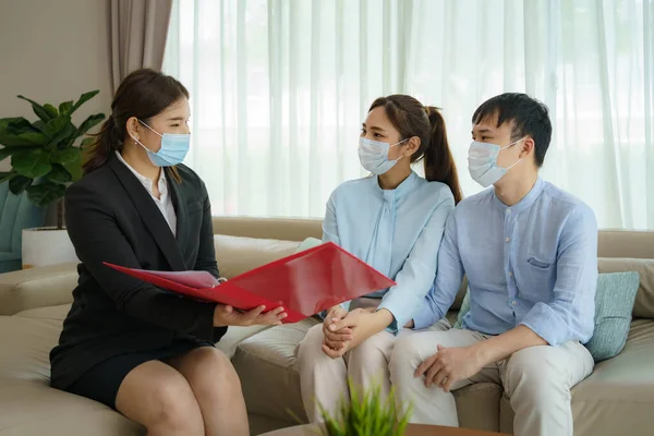 Asiatische Versicherungsmakler Bieten Asiatischen Paaren Heimischen Wohnzimmer Details Zum Krankenversicherungsschutz — Stockfoto