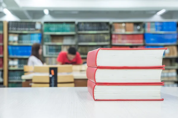 Une pile de livres avec bibliothèque au dos — Photo