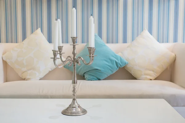 Candeliere con cinque candele sul tavolo con divano sullo sfondo — Foto Stock