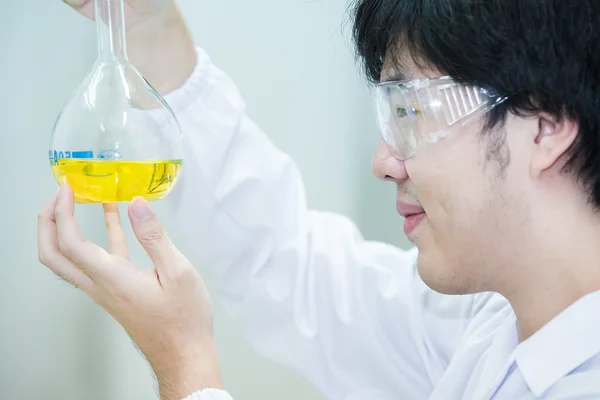 Asian cientific researcher looking closely at the result of the — Stock Photo, Image