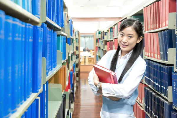Joven asiática estudiante en la biblioteca — Foto de Stock