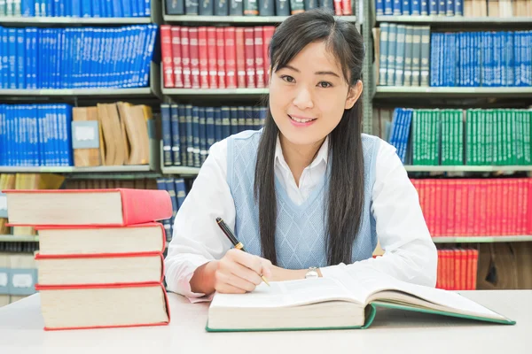 Asian university student reading book in library at university — Stock Photo, Image