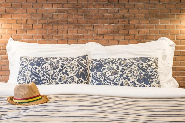 Жіночий капелюх і подушка на ліжку готельного номера — стокове фото