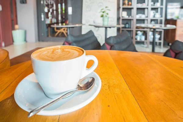 Искусство латте кофе на деревянном столе в кафе — стоковое фото