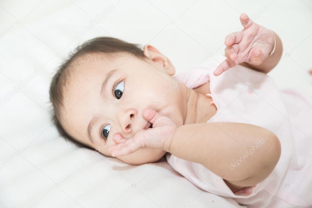 Asian baby sucks his fingers