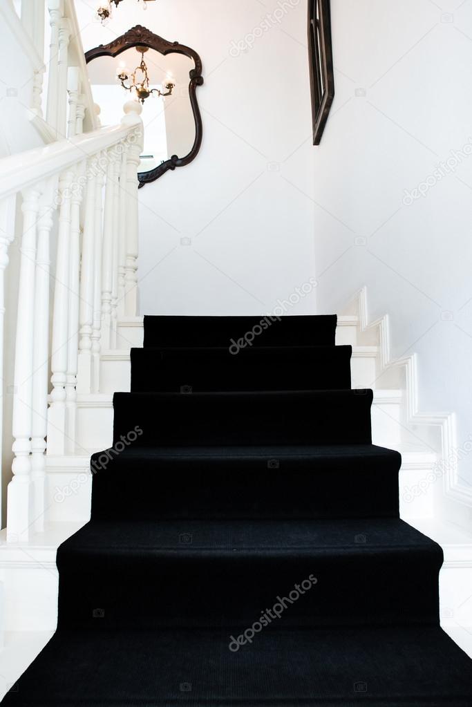 Modern staircase of a classic building with black carpet