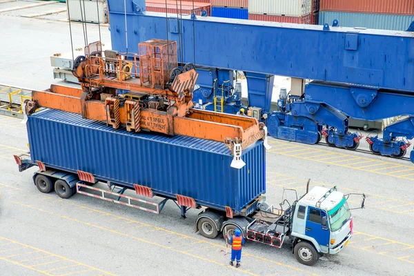 Контейнерна вантажівка чекає завантаження контейнерної коробки на вантажний корабель — стокове фото