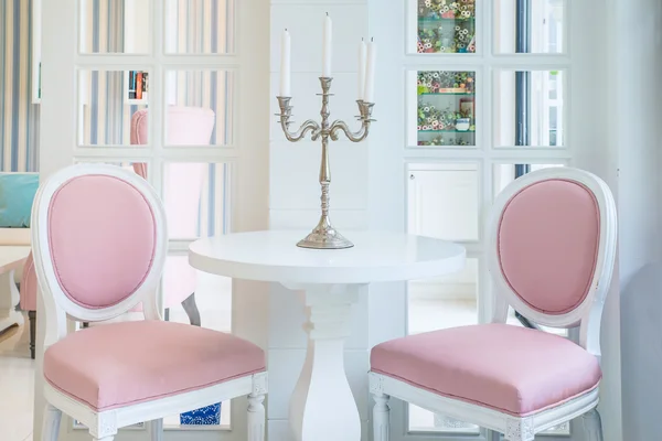 Mesa blanca y silla rosa con vela sobre mesa en salón —  Fotos de Stock