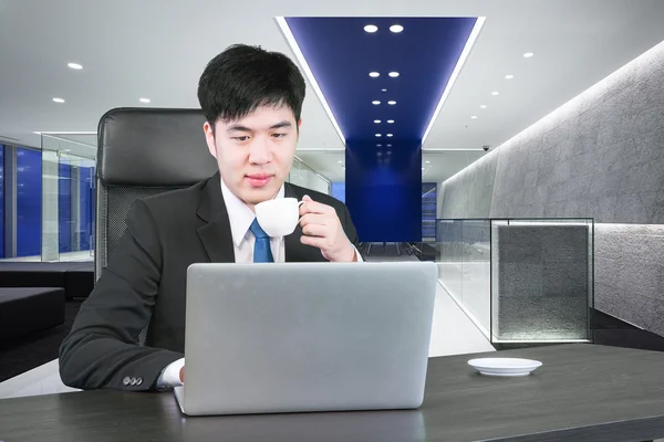 Asiático empresario bebiendo café y trabajando con el ordenador en m — Foto de Stock
