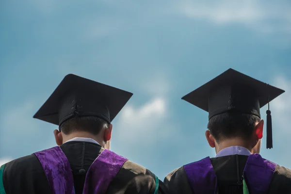 Back of graduates with blue sky — Stock Photo, Image