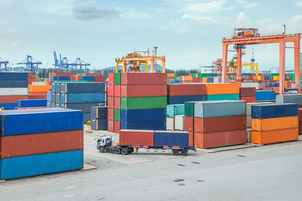 Camión lleva contenedor a un almacén en muelle — Foto de Stock