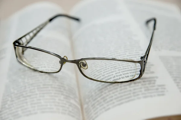 Närbild av läsglasögon på boken — Stockfoto