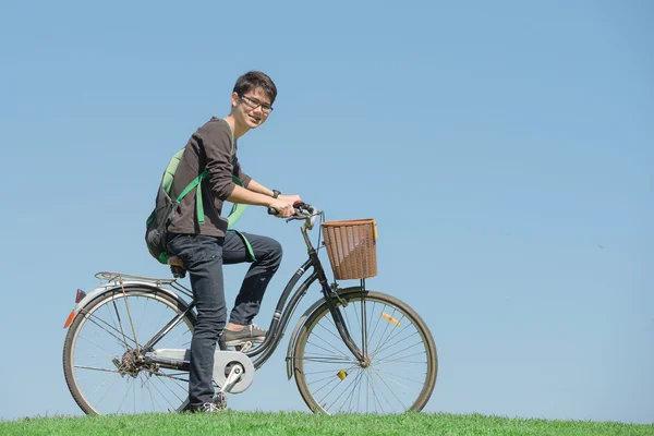 Estudante feliz monta uma bicicleta no parque — Fotografia de Stock