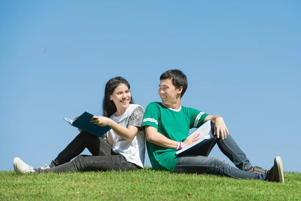 Casal de estudantes asiáticos ao ar livre olhando muito feliz — Fotografia de Stock