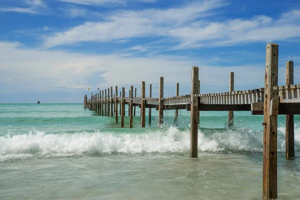 Wellen krachen ans Ufer und Holzbrücke auf See — Stockfoto