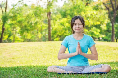 Asyalı kadın yoga egzersizleri açık park yapıyor