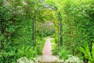 Decorative arched iron gateway to a garden clipart