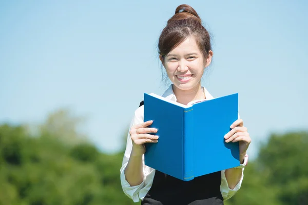 Étudiant asiatique dans le parc avec livre et note de cours — Photo