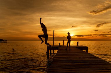 Kadın siluetleri iskeleden denize atlamak
