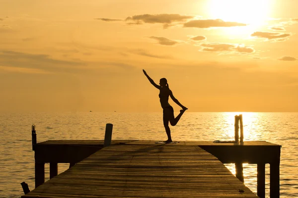 İskele iskele ahşap köprü üzerinde yoga yapıyorum kadın silüeti