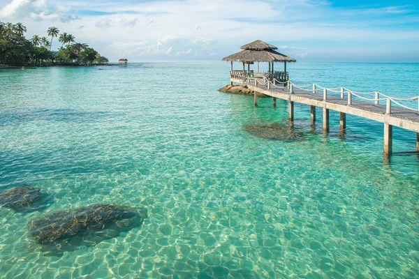 Cabaña tropical y puente de madera en el complejo vacacional. Viaje de verano — Foto de Stock