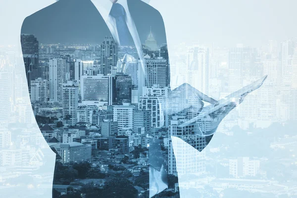 Double exposure of city and business man using digital tablet — Stock Photo, Image