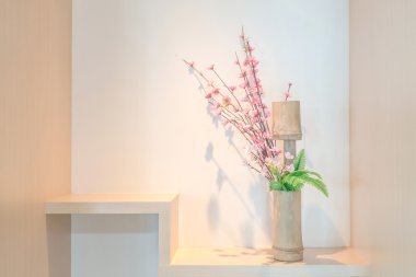 Bir raf üzerinde kiraz çiçeği bambu vazo