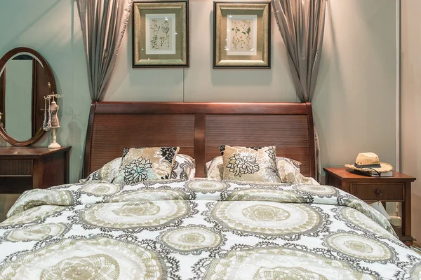 Mobília de quarto de luxo. Cama de madeira esculpida com travesseiros e lâmpadas — Fotografia de Stock