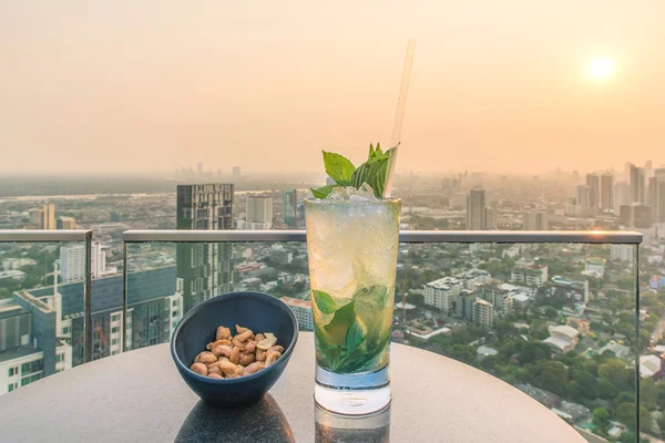 Mojito cocktail en cashewnoten op tafel in bar op het dak — Stockfoto