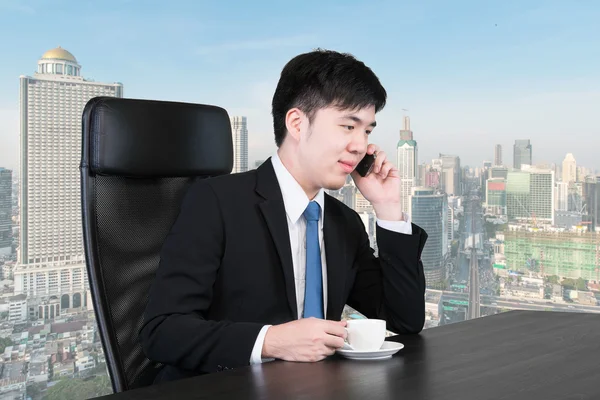 Hombre de negocios asiático hablando por teléfono en el edificio de oficinas altas — Foto de Stock