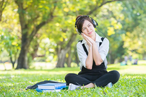 漂亮的亚洲年轻女子戴着耳机在户外。享受 M — 图库照片