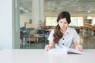 Asyalı öğrenci üniforma okuma kitabı, sınıf içinde