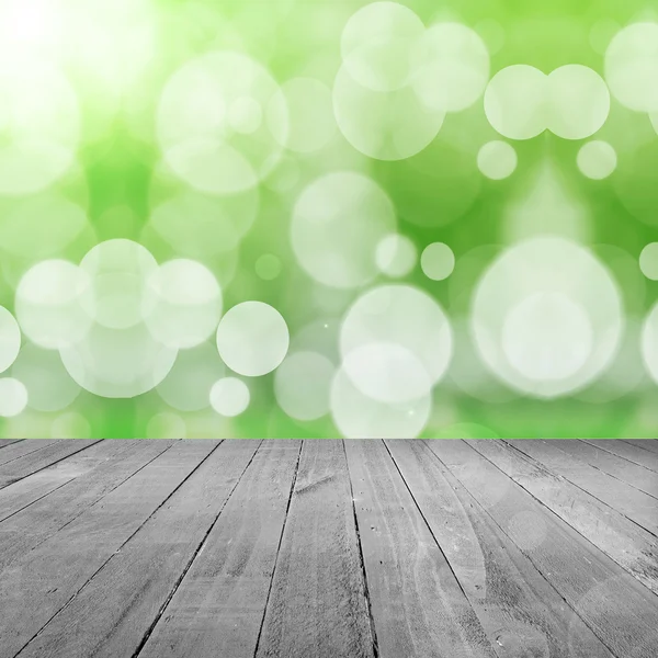 Green background with bokeh and wood floor — Stock Photo, Image