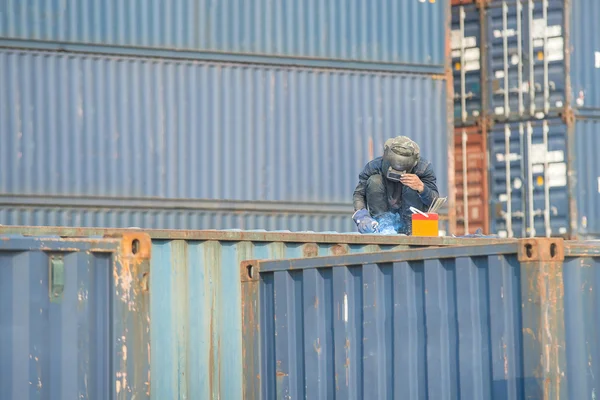 Worker welding to repair container box in port — Stock Photo, Image