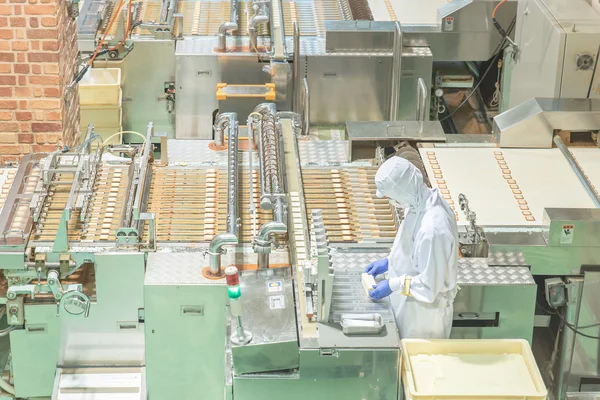 Werknemer werkt met machine in koekjesfabriek — Stockfoto