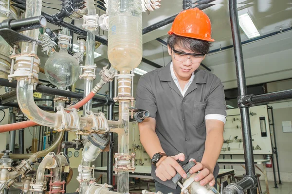Asian engineer student turning pipeline pump for training in lab — 图库照片