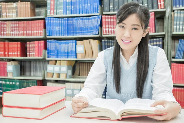 Estudiante asiático leyendo libro en la biblioteca de la universidad — Foto de Stock