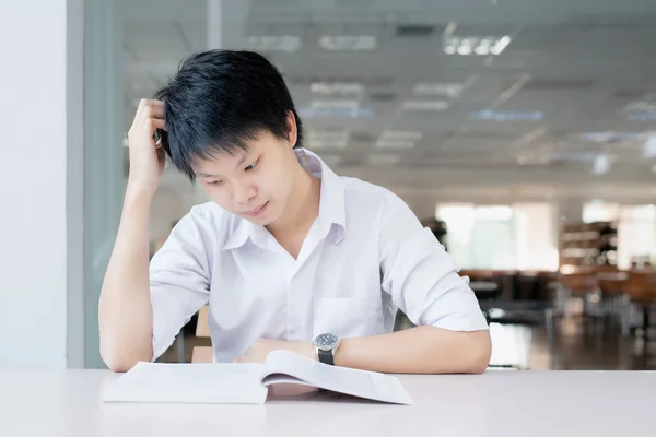 Sad student reading book in classroom — Stock Photo, Image