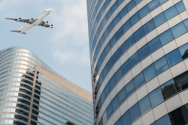 Shot of airplane flying above skyscrapers in City of Bangkok downtow