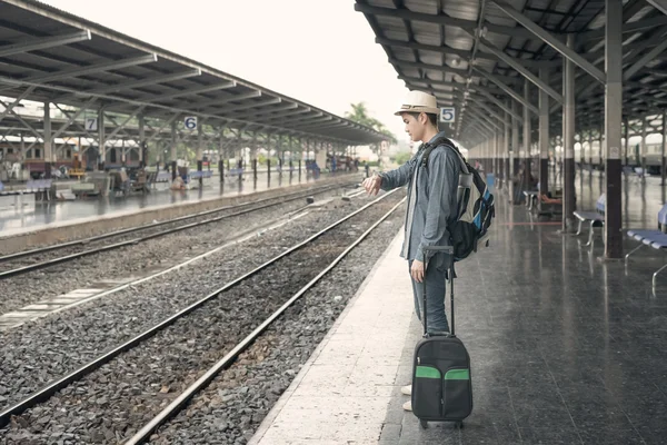 Atraso no comboio. Jovem asiático homem olhando em seu relógio enquanto espera — Fotografia de Stock