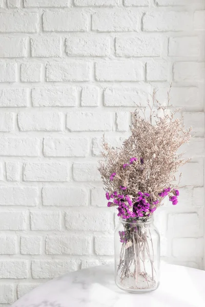 Zusammensetzung von getrockneten Blumen auf weißem Mauerziegel im Hintergrund — Stockfoto