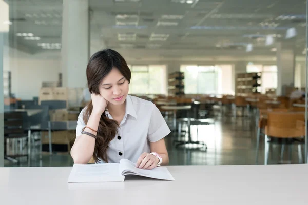 Asijská studentka v jednotných čtení knih v učebně — Stock fotografie