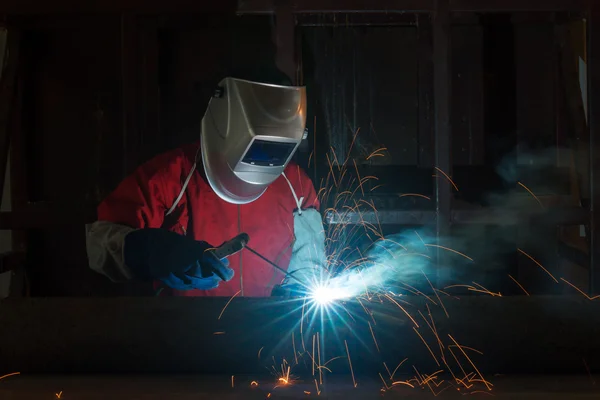 Worker with protective mask welding metal in factory — Stock Photo, Image