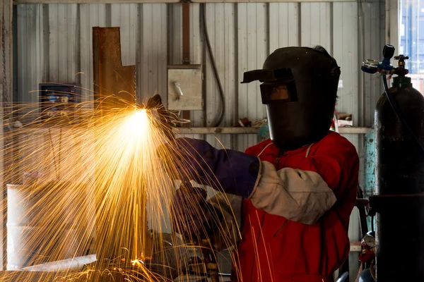 Worker with protective mask welding metal in factory — Stock Photo, Image