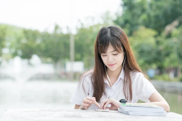 Estudante asiático com uniforme usando smartphone — Fotografia de Stock