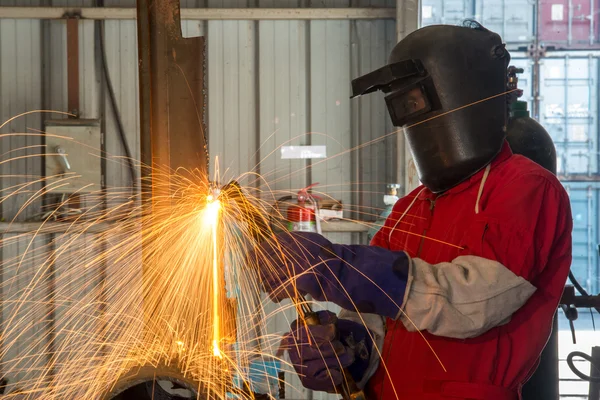 Worker with protective mask welding metal in factory — Stock Photo, Image